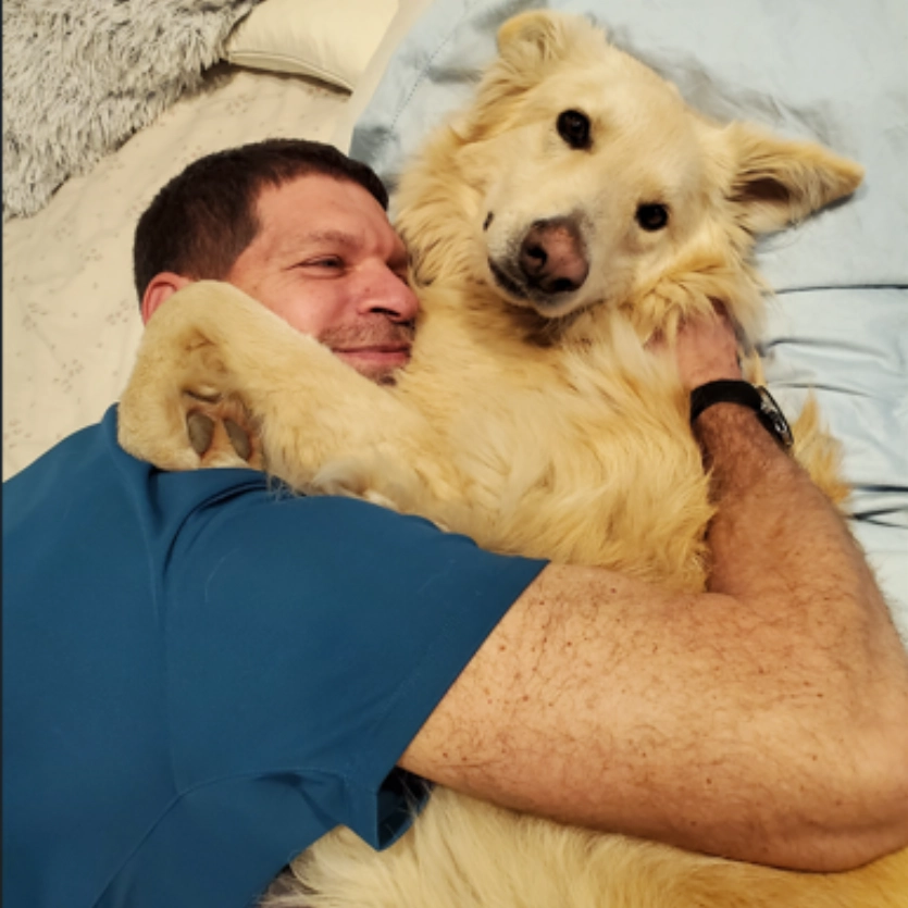 Man hugging fluffy dog Dr Shmueli hugging fluffy dog
